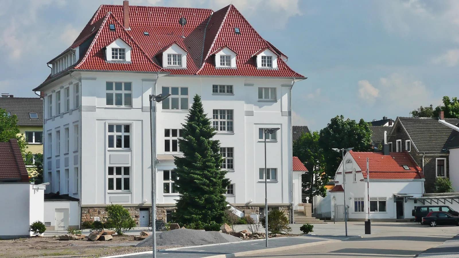 Weißes Verwaltungsgebäude mit rotem Walmdach und Gauben an der Annenstraße, ursprünglich für das Krupp-Zweigwerk Annen gebaut
